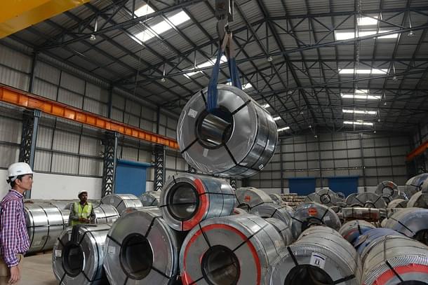 Indian workers store steel coils unloaded at a new private freight terminal near Ahmedabad. (SAM PANTHAKY/AFP/GettyImages)